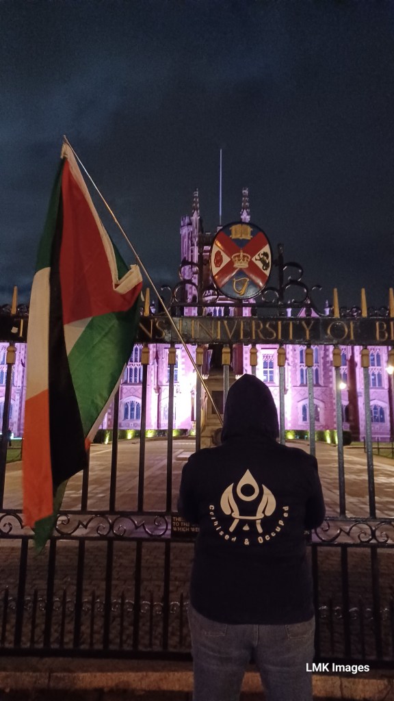 Protestor at QUB protest for Palestine holding Irish and Palestinian flags